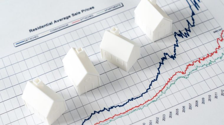 Growth in real estate price market White miniature house models on graph indicating growth in real estate prices market