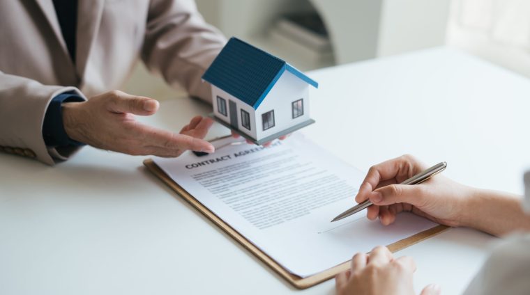 Real estate agent and realtor general liability insurance busine Real estate agent and realtor general liability insurance businessman professional discussing and consultant with house toy model building before sign a contract with law concept.